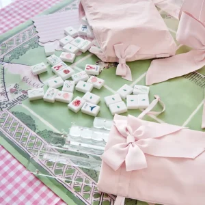 Mahjong tiles with designs on a pink and green mat #color_ballet pink bow