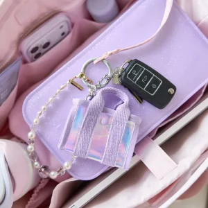 Purple cardholder with keychain and car key model on a pink surface #color_iridescent