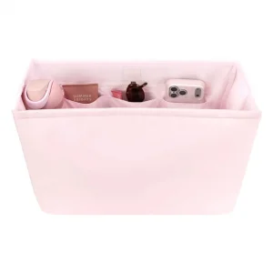 Pink fabric organizer with compartments containing various items on a white background #color_ballet pink