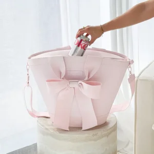 Pink tote bag with a bow being held by a hand against a light background #color_ballet pink bow