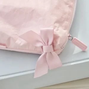 Pink pouch with a bow and a visible brand tag on a light gray background #color_ballet pink bow