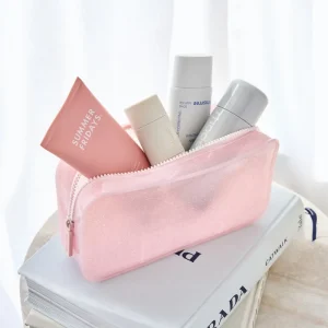 Pink cosmetic bag with skincare products on top of a book #color_ballet pink twinkle