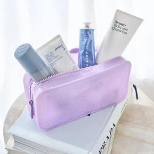 Purple cosmetic bag with skincare products on a white surface #color_stardust twinkle