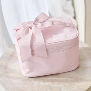 Pink cosmetic bag with a bow on a marble surface